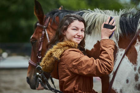 Whoever said you cant buy happiness never had a pony. Shot of a teenage girl brushing her ponys hair on a farm.の写真素材