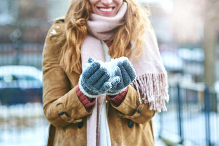 Now I just have to make a snowball. Shot of an unrecognizable woman enjoying being out in the snow.の写真素材