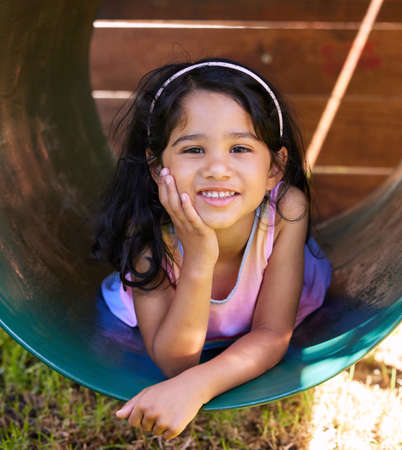 Here to render some sunshine in your life with her adorable smile. Shot of an adorable little girl spending time outside.の写真素材