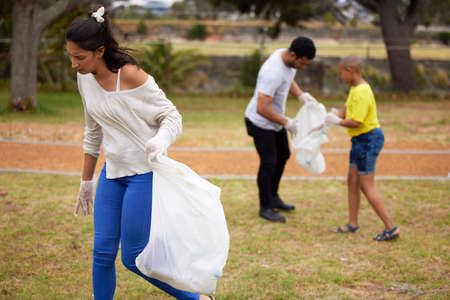 With great power comes great responsibility. Shot of a group of people picking up trash in a park.の写真素材