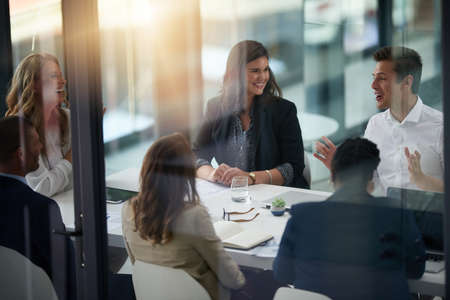 Throwing some winning concepts and ideas around. Shot of a group of businesspeople having a meeting in an office.の写真素材
