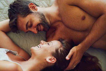 You feel like heaven to touch. High angle shot of an affectionate couple lying in bed together.