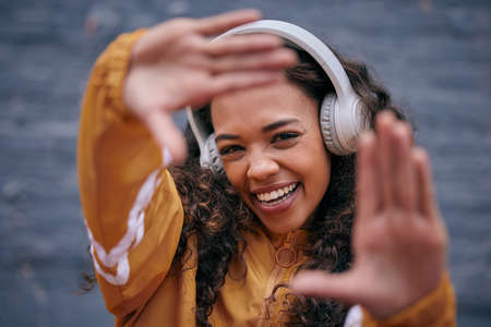 Good music is what makes me happy. Cropped shot of a beautiful young woman wearing headphones while...