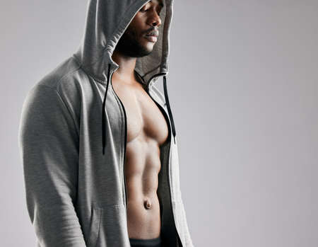 Dont wish for it, work for it. Studio shot of a young muscular man posing against a grey background.の写真素材