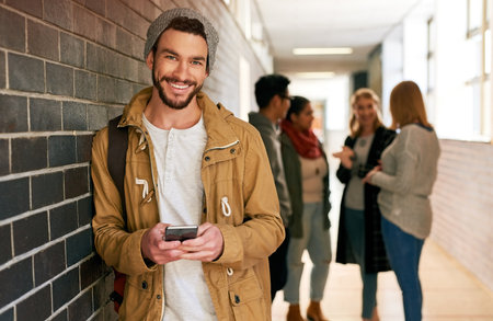 Ive made some connections on campus. Portrait of a young male university student standing in a campus corridor with his classmates in the background.の写真素材