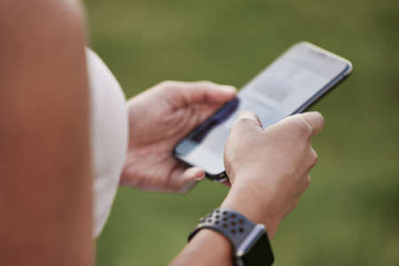 Monitoring her progress on a new fitness app. Closeup shot of an unrecognisable woman using a...