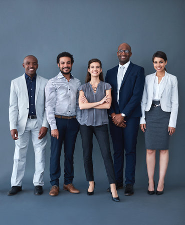 We here for the opportunity. Studio shot of corporate businesspeople posing against a gray...