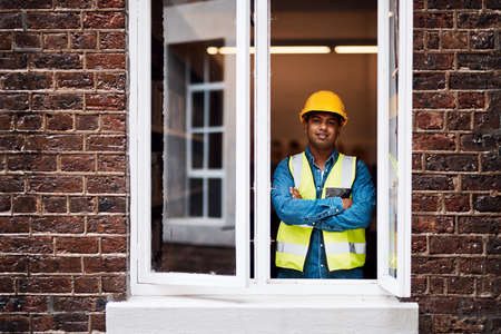 My team and I are going to transform this building. Shot of a young engineer standing in the window...