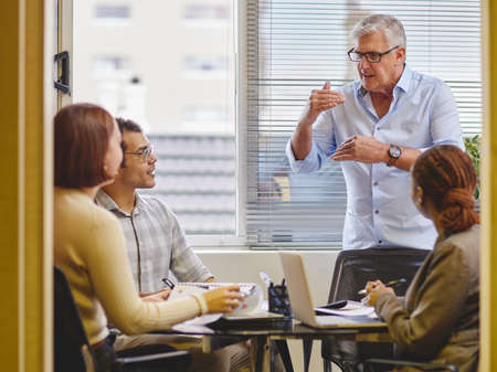 Let me explain. Cropped shot of a handsome mature businessman explaining an idea to his colleagues...