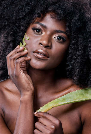Aloe is perfect for DIY skincare. Shot of a beautiful young woman posing with an aloe vera plant...