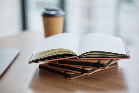 Goals should be written. Shot of a stack of books in a table in a modern office.の写真素材