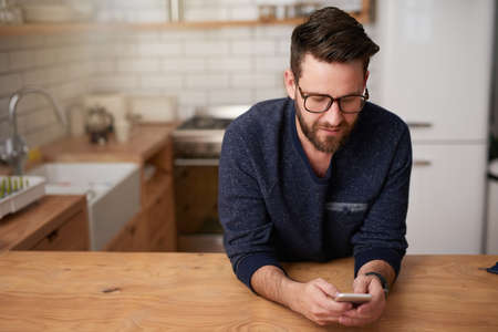 Making plans for his day of leave. Cropped shot of a handsome young man sending a text message while...
