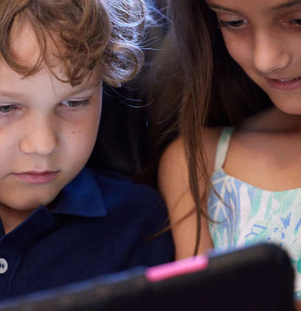 Theres always something fun and educational to do online. Shot of a little boy and girl using a digital tablet while sitting together.の写真素材