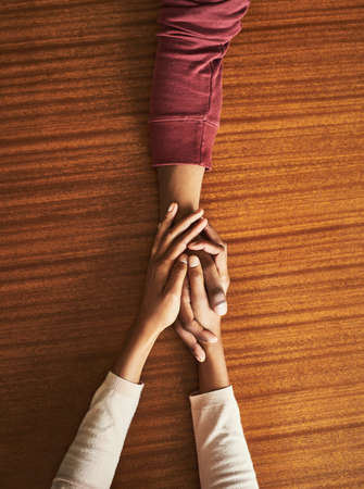 Here for you, every step of the way. Closeup shot of two unrecognizable people holding hands in...