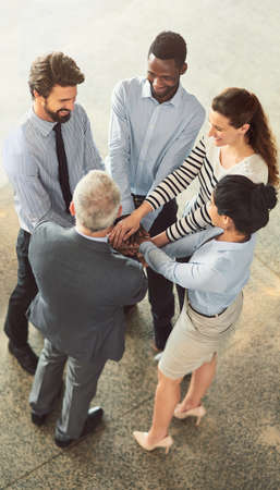 Meeting on the move. High angle shot of businesspeople standing in a office lobby.の写真素材