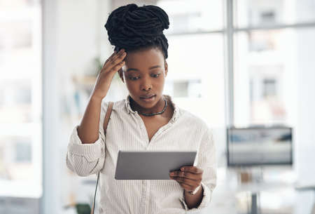 I have an emergency to attend to. Shot of a businesswoman using her digital tablet at work.