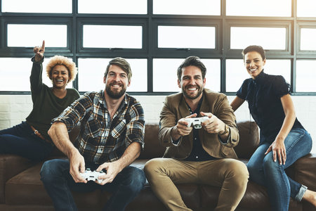 Switch things up at the office. Shot of a group of designers having fun while playing games.