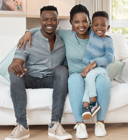 We spend as much time together as a family. Full length shot of a young couple sitting in the living room at home and bonding with their son.の写真素材