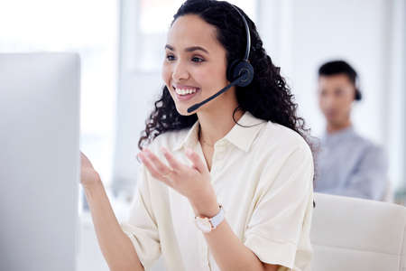 Shell simplify the matter for you. Shot of a young call centre agent working on a computer in an...