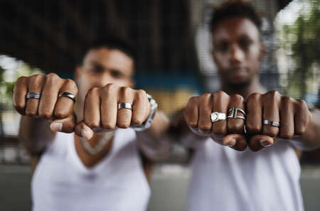 Kiss the ring. Closeup shot of two male gangsters hands showing off their rings with clenched fists.
