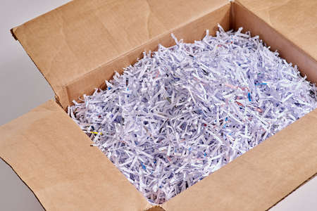 Shredded paper is great for packing. Studio shot of shredded paper in a cardboard box against a grey...