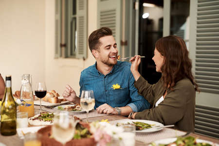 We love food but we love each other more. Cropped shot of a couple enjoying a meal together in the...