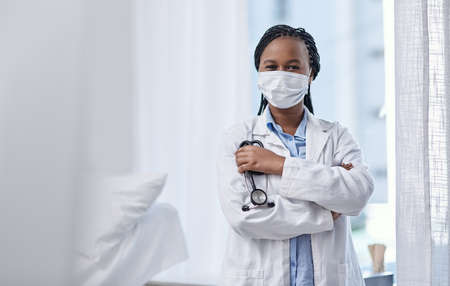 Putting passion into community care. Portrait of a young doctor wearing a face mask and holding a...