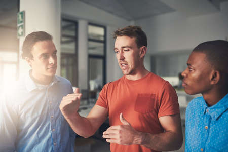 Expanding their goals for a greater success. Shot of three colleagues having a discussion in an...
