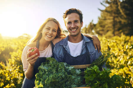 They look good and taste even better. Shot of a young man and woman working together on a farm.の写真素材