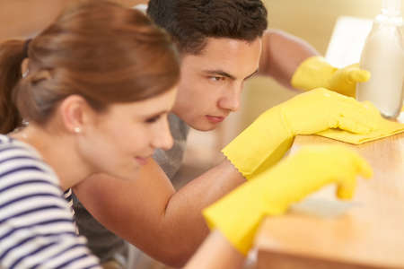 Theyve perfected cleaning to an art. Shot of a happy young couple cleaning their kitchen together.