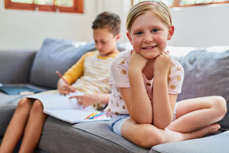 My time to chill, my brother has homework to do. Cropped shot an adorable brother and sister doing...