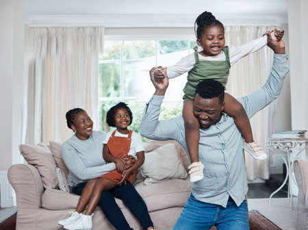 Fun is all they have planned for the day. Shot of a happy family having fun while relaxing together at home.の写真素材