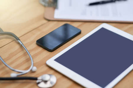 Doctors daily essentials. Closeup shot of a tablet, smartphone, clipboard and stethoscope on a...