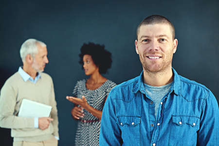 Ill put my best people on it. Studio portrait of a young businessman posing with his colleagues in the background.の写真素材