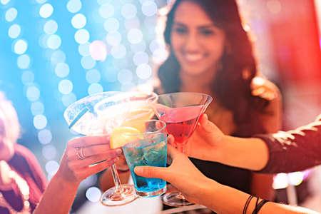 Toast to the weekend. Cropped shot of a group of women celebrating with cocktails at a party.の写真素材