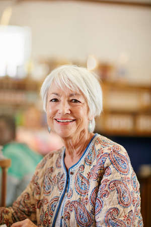She lives life with a smile. Portrait of a smiling senior woman in a cafe.