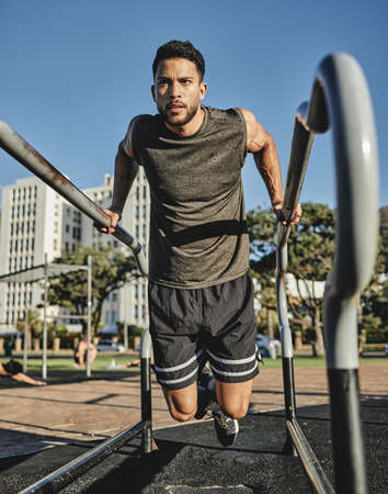 A little effort goes a long way. Shot of a muscular young man exercising at a calisthenics park.