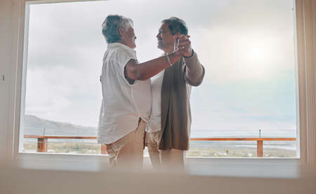 I love when we dance to our favourite songs. Shot of a senior couple dancing together at home.