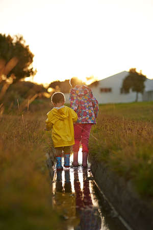 Splish splashing the day away. Shot of a brother and sister splashing in water while playing...