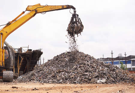 Industrial re-purposing. Cropped shot of an excavator sorting through a pile of scrap metal.
