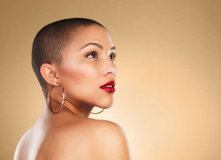 You are more than beautiful. Studio shot of a beautiful young woman posing against a brown background.の写真素材