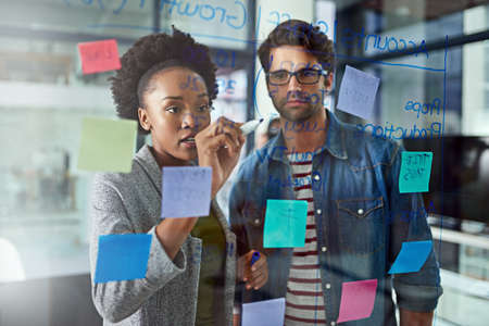 Two heads are more effective than one. Cropped shot of coworkers brainstorming in a modern office.