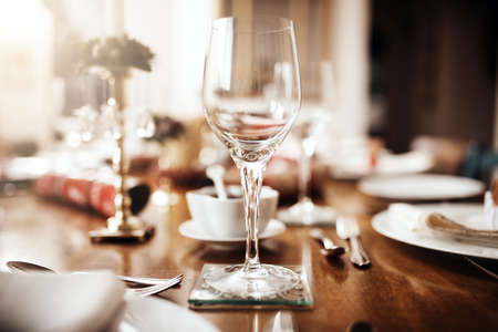 The scene is set for some Christmas festivities. Closeup shot of a wineglass on a table at...
