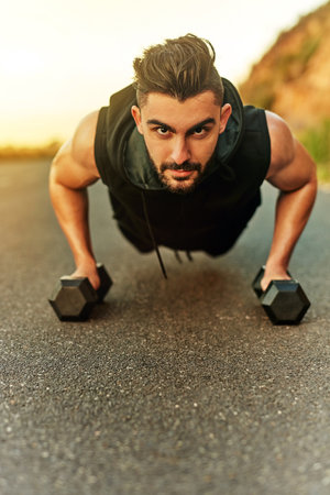 Strength is acquired. Shot of a young man exercising outdoors.の写真素材