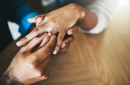 I want to show you how much I love you. Cropped shot of a man putting an engagement ring onto his girlfriends finger.の写真素材