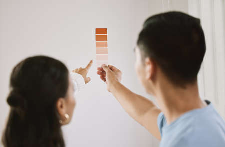 I really like this shade. Shot of an unrecognizable couple standing together and planning the interior design of their new home.の写真素材