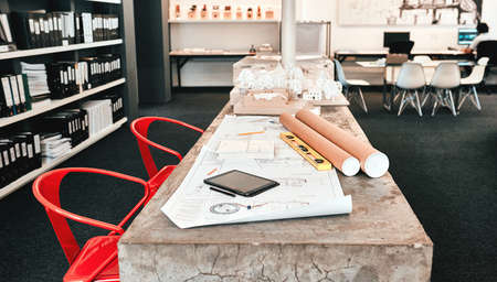 The designers corner. Still life shot of an architects blueprints placed on a desk in a modern...