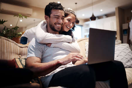 Looks like youre winning, babe. Shot of a man using his laptop while his girlfriend embraces him...