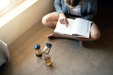 Every word leads you through a journey. High angle shot of an unidentifiable young man reading a...