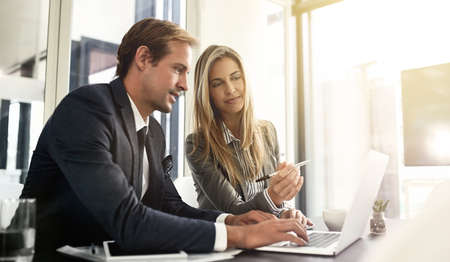 One hundred percent focused on their work. Shot of a two executives working together in an office.